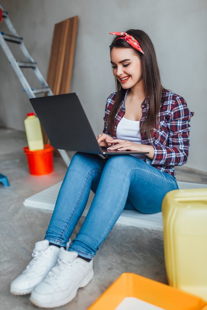 Young woman with laptop doing repairs at new home!